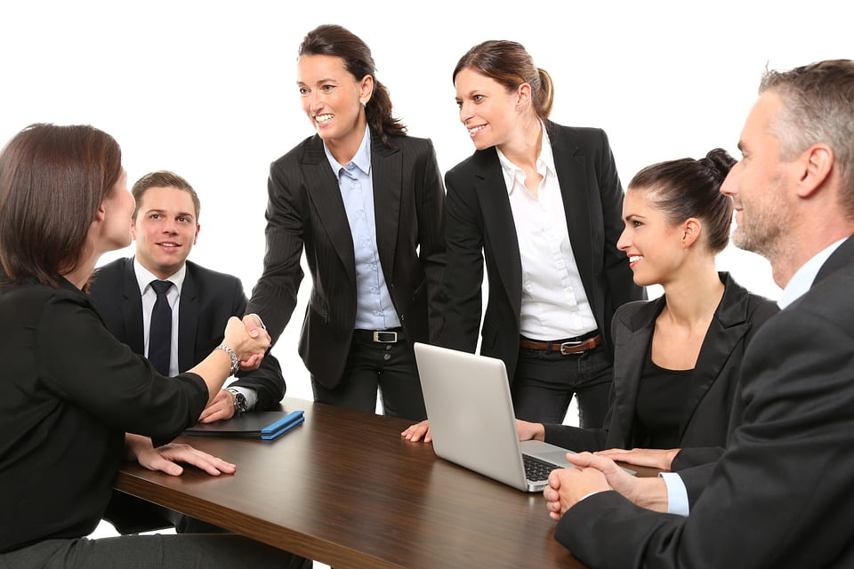 Group of friendly business men and women shaking hands with no friction